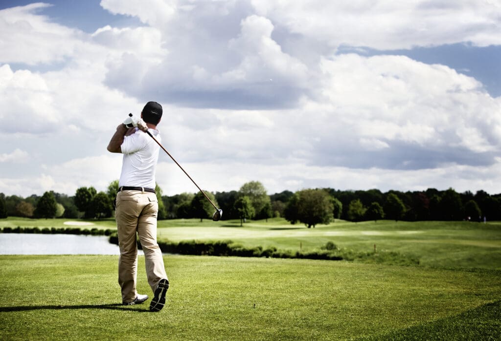 Male,golf,player,teeing,off,golf,ball,from,tee,box,